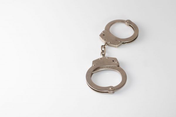 A closeup shot of a metal handcuffs on a white background